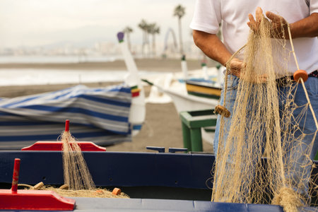 Fishing fishing net in the hands of fishermen. On the beach, sea thoroughly