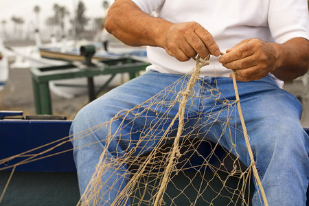Fishing fishing net in the hands of fishermen. On the beach, sea thoroughly