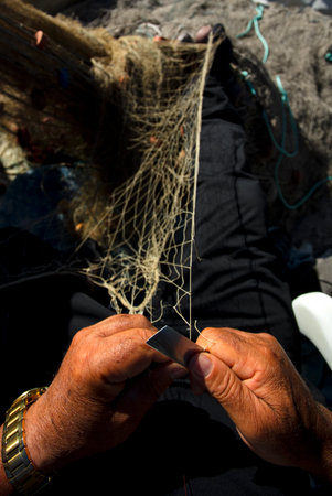 Mediterranean fisherman, Malaga coast, weaves and repairs a fishing net, black and white photography