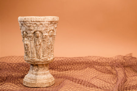 stone chalice with fishing net on a brown backgroundの写真素材