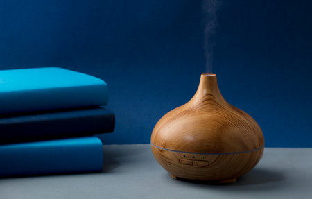 wood fragrance on the table with natural oils essence vapor, with blue and teal colored booksの写真素材