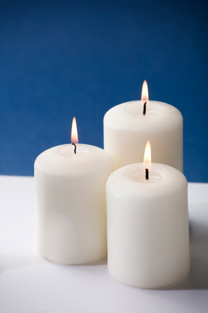 three burning candles on a blue backgroundの写真素材