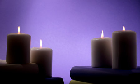 candles and books with purple background, central space for textの写真素材