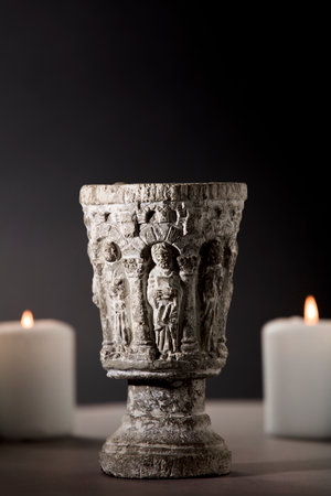 Old romantic wine glass, chalice, with candles, dark gray background, medievalの写真素材