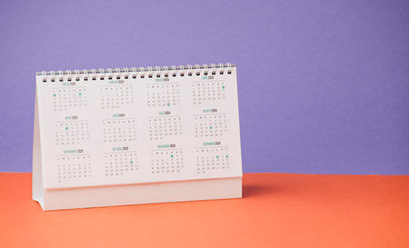 desk calendar with year 2024 and days, on purple and orange deskの写真素材
