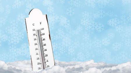White outdoor thermometer with a temperature of zero degrees in the snow. Cold ice and freeze design...