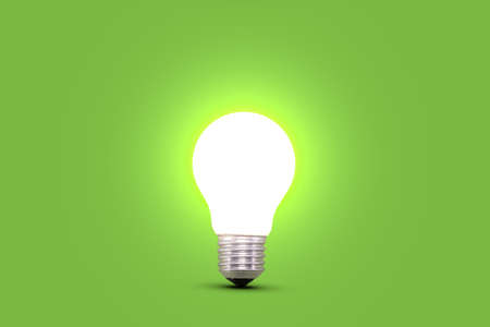 Glowing light bulb isolated on green background. Concept for ideas, innovation and savings.の写真素材