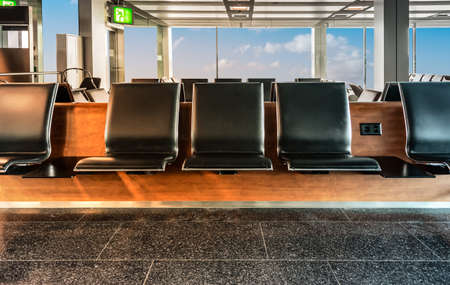 Row of empty waiting seats in the departure lounge of airport. Travel and business concept.
