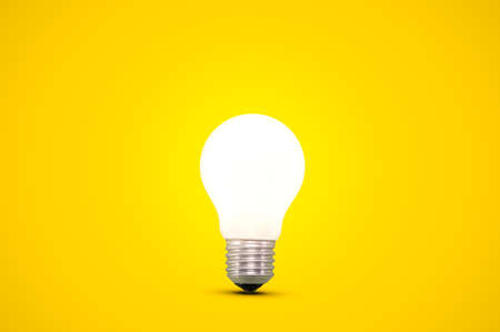 Glowing light bulb isolated on a bright yellow background.