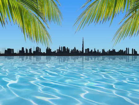 Palm trees at the pool. Silhouette of Dubai skyline in the background.の写真素材