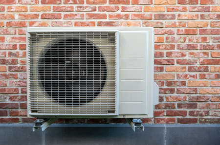 Heat pump air conditioning outdoor unit hanging on wall.の写真素材