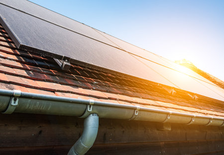 Dusty solar panels on roof of pool house against blue sky. Alternative energy source.の写真素材