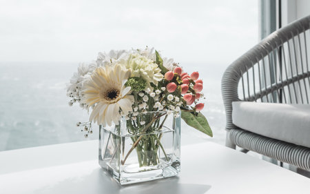 Beautiful white bouquet of flowers in vase on table of cruise ship.の写真素材