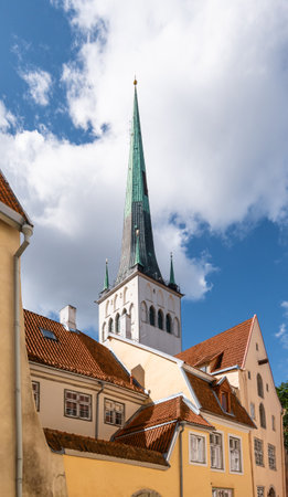 Tower of St Olaf's Church behind traditional buildings in old town of Tallinn, Estonia.の写真素材