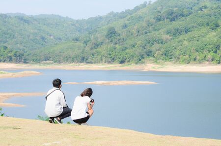 Young couple relax beside the dam after jogging. Health and fitness.の写真素材