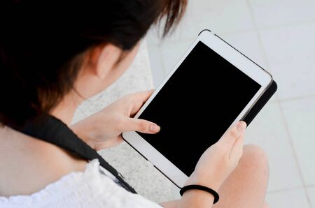 A girl hand holds white digital tabletの写真素材