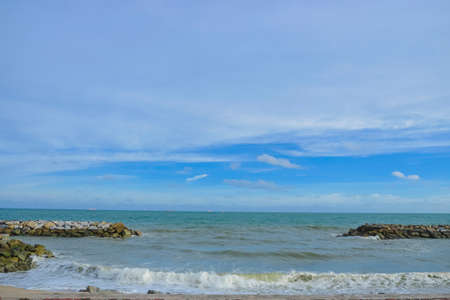 The armourstone wall for break the waves in the sea with the blue sky behind.