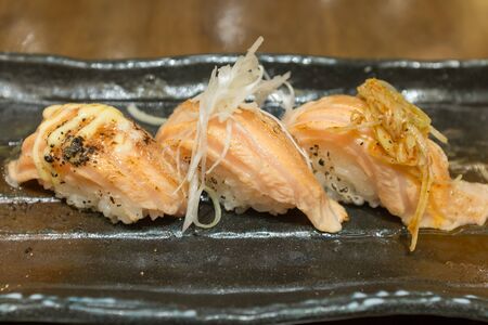 Assorted Salmon Suhi on black ceramic plateの写真素材