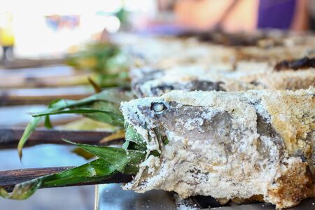 fresh delicious grilled fish Striped snakehead fish with salt. dark burn skin with charcoal outdoor...