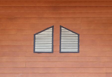 two windows at wood wallの写真素材