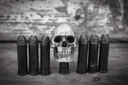 still life and vintage of skull human with handcuff and bullet .375 on old wooden  backgroundの写真素材