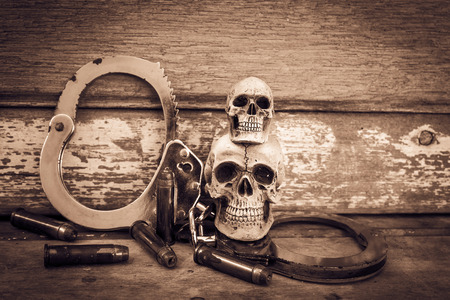 still life and vintage of skull human with handcuff and bullet .375 on old wooden  backgroundの写真素材