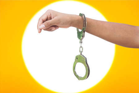 hand women in shackle on light and yellow backgroundの写真素材