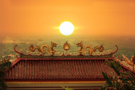 Golden Dragon sculpture on the Monastery sunset background