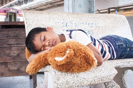 Little boy sleep alone at the train stationの写真素材