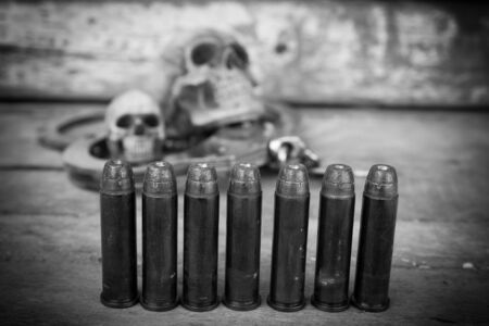 still life of skull human with handcuff and bullet .375 on old wooden backgroundの写真素材