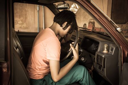 asian girl sad alone sitting  in the old car,vintage tone