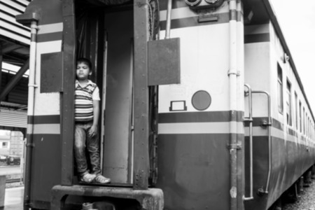 blurry abstract of the little boy standing alone and hand hold white bear at inner trainの写真素材