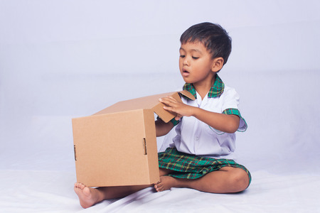 portrait of asian boy play brown box on white backgroundの写真素材