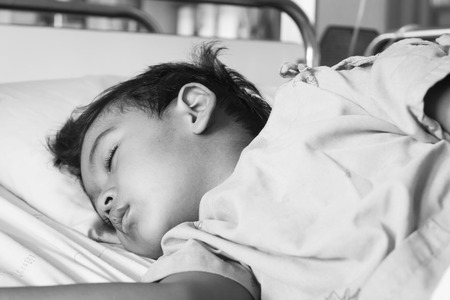 little asian boy sick sleep on the patient  bed  in the Hospital ,black and white toneの写真素材