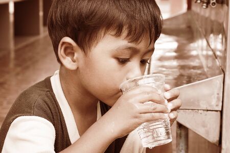 a little asian boy drinking water vintage toneの写真素材