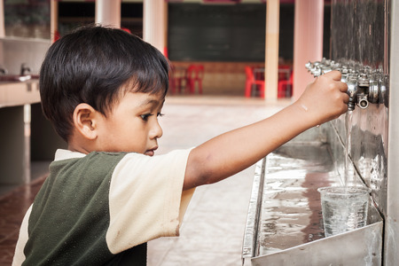 little asian boy press the drinking waterの写真素材