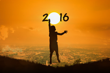 Silhouette of little boy  jump touch sunset new year 2016