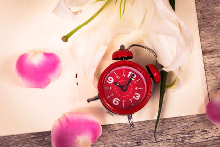 lilly flower and watch on note book wooden backgroundの写真素材