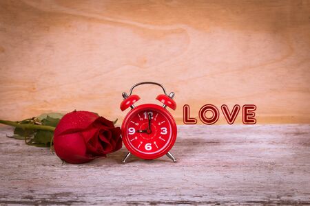 vintage watch and red rose on wooden backgroundの写真素材