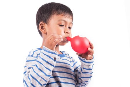 happy little boy blowing balloonの写真素材