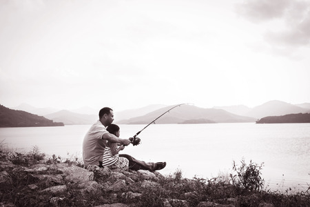 son and dad fishing at dam,black and white toneの写真素材