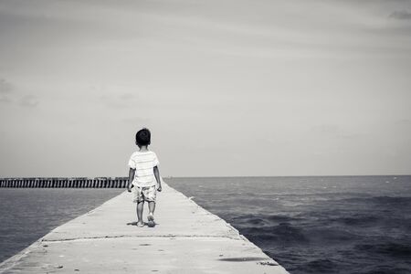 little boy walking on  the bridge,black and white toneの写真素材