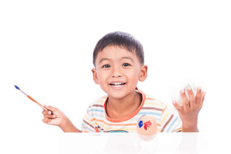 little boy play paint easter eggの写真素材
