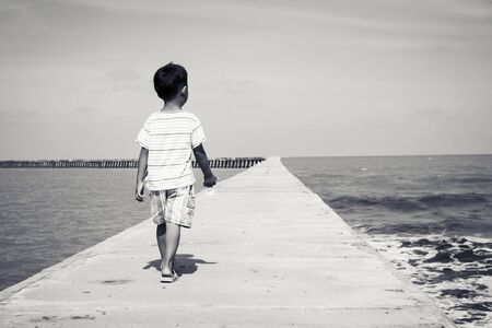 little boy walking on  the bridge,black and white toneの写真素材