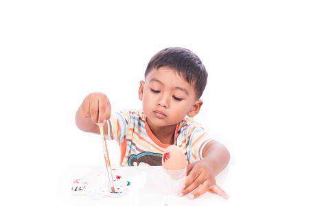 little boy play paint easter eggの写真素材