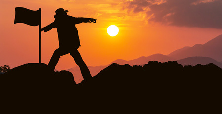 concept success,man success use hand pointing forward sunset backgroundの写真素材