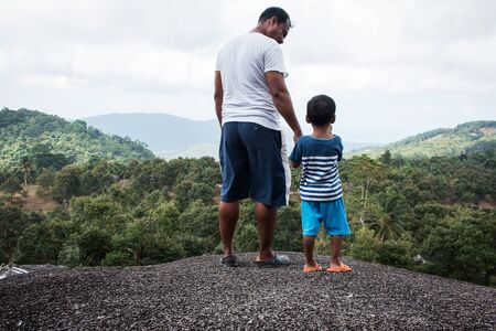 father and son standing on the top mountainの写真素材