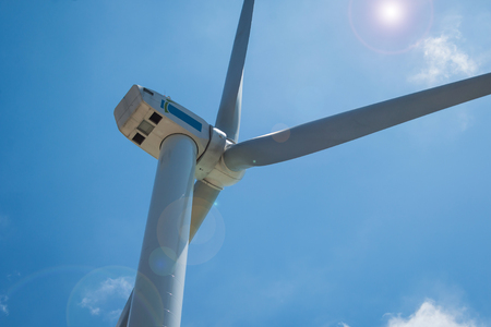 Cloes up wind turbine towers on blue sky background