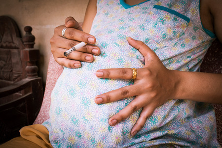 Close-up of pregnant women smokingの写真素材