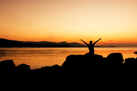 Women happy and free open arms on beach sunset backgroundの写真素材